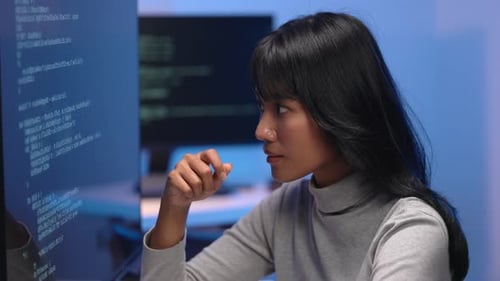 Asiatische Entwicklerin denkt beim Debuggen von Code tief nach