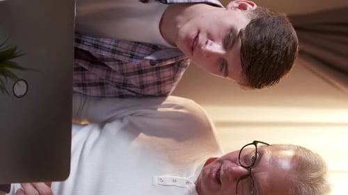 Young Adult and Senior Adult Use Laptop Together