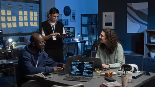 Junge Gruppe von drei verschiedenen IT-Spezialisten, die über Softwareentwicklung diskutieren