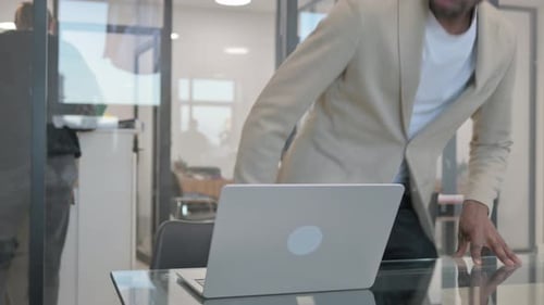Man Works on Laptop in Modern Office