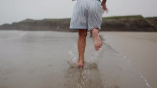 Child Joyfully Running on a Peaceful Beach at Sunset