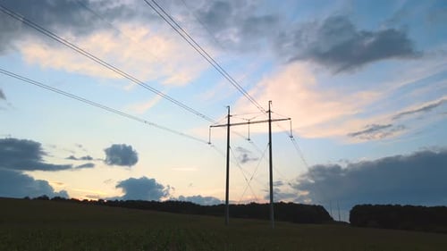 Dark Silhouette of High Voltage Tower with Electric Power Lines at Sunset Transfer of Electricity