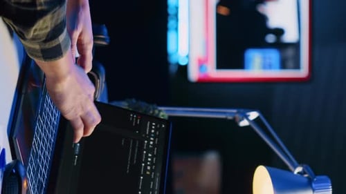 Vertikaler Videoprogrammierer schreibt Code auf den Laptop-Bildschirm, während er im Büro einer Wohnung mit Java ist