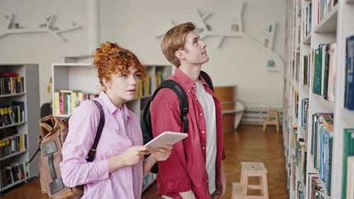 Os calouros vêm ao Rack in Library para escolher livros para estudar