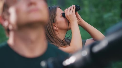 Observation des
oiseaux dans le parc. Couple observe les oiseaux avec des jumelles et un appareil photo avec téléobjectif. Oiseau amateur