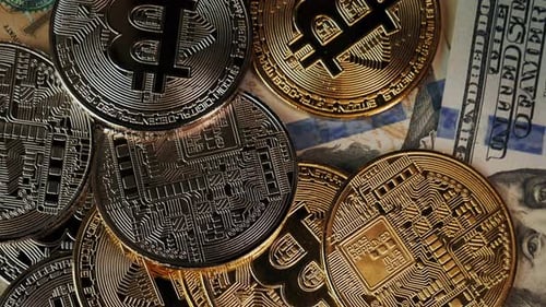Close-up of Bitcoin Coins and Hundred Dollar Bills