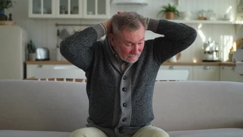 Mature Man Massaging Temples Experiencing Headache