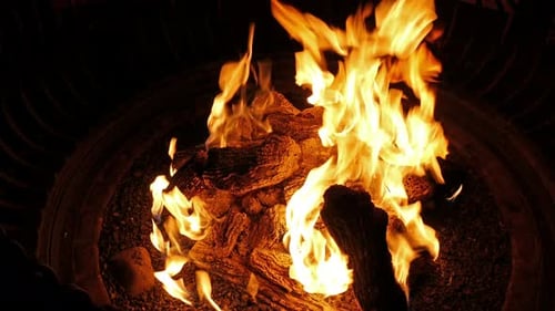 Burning Logs Glowing in a Dark Fire Pit