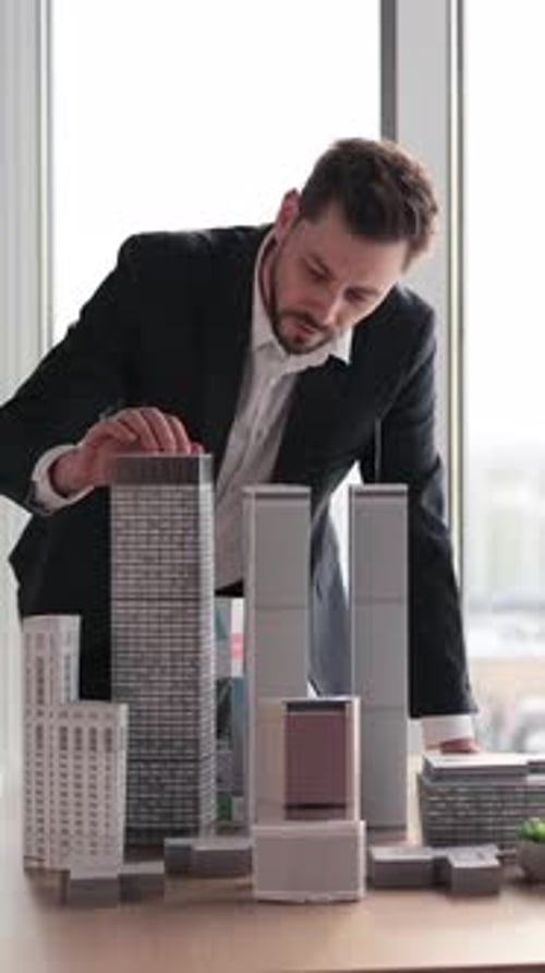 Architect Inspecting Building Models