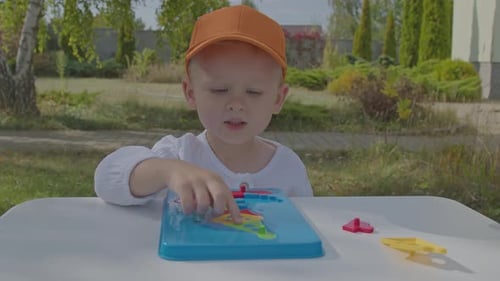 Three Year Old Boy Putting Togeather A Puzzle In Home Garden 3