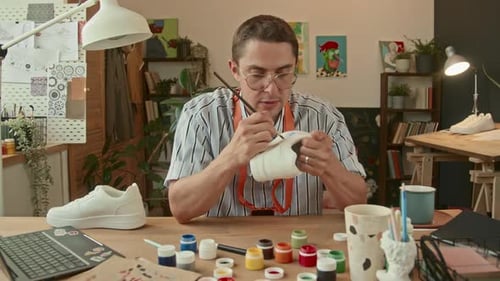 Young Adult Designing and Painting Shoes Indoors