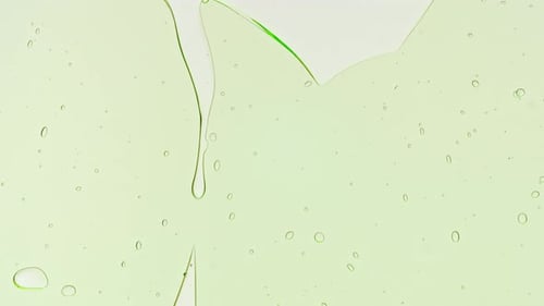 Transparent Green Cosmetic Gel Fluid With Molecule Bubbles and Oil on White Background