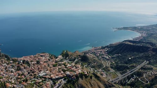 Hoch oben in den Bergen über Stadtgebieten in natürlicher Landschaft fliegen. Atemberaubende Panoramaaufnahme