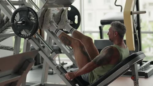 Man Doing Leg Press Exercise at Gym for Strength Training