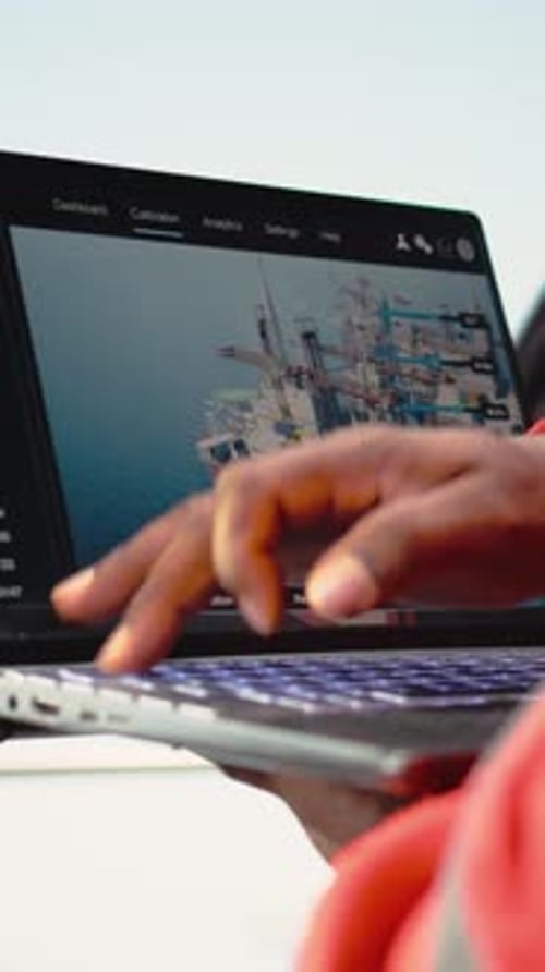 Vertikale Video-Nahaufnahme eines Laptops, der von Bohranlagenarbeitern zur Überwachung von Infrastruktursystemen verwendet wird
