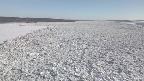 Aerial wide shot of the great river covered with ice and snow during strong winter in northern Europ