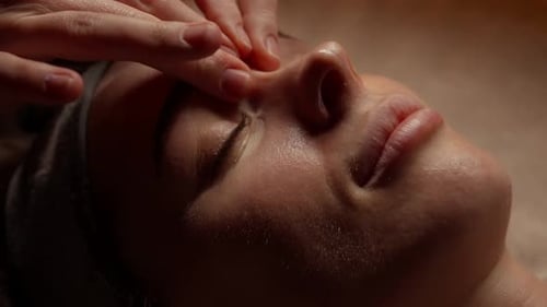 Woman Receives Relaxing Facial Massage at Day Spa