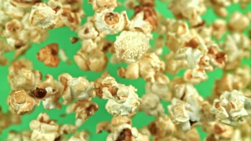 Popcorn Pieces Floating Upwards on Green Background