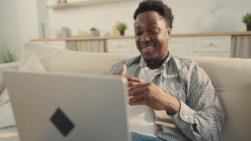 Man Smiling During Video Call on Laptop