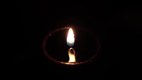 Close Up of Lit Candle Burning in Darkness
