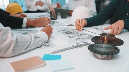 Collaborative team meeting in a modern office discussing engineering designs and project plans with