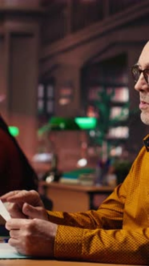 Vertical Video Aged Man in a Study Area Surrounded By Library Books and Paperwork