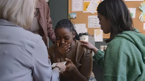 Supportive Friends Comforting Crying Peer in Office