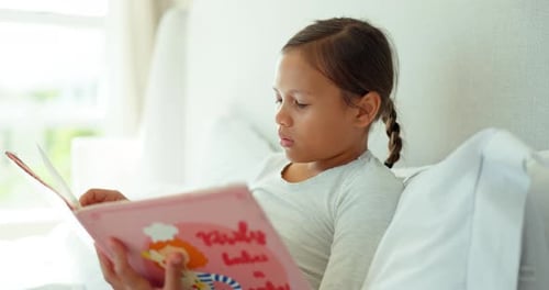 Bed, reading and girl with book in home for story time, child development and learning literature