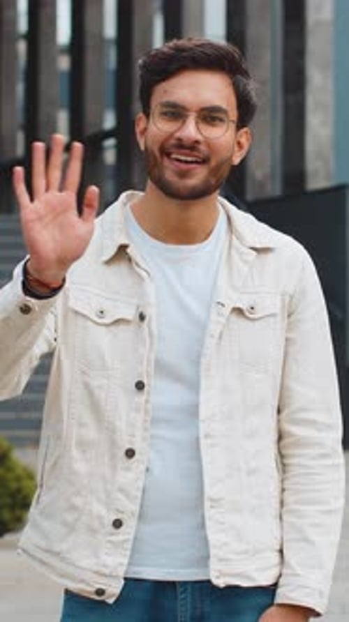 Indian Man Smiling Friendly at Camera Waving Hands Hello Hi Greeting or Goodbye in City Street