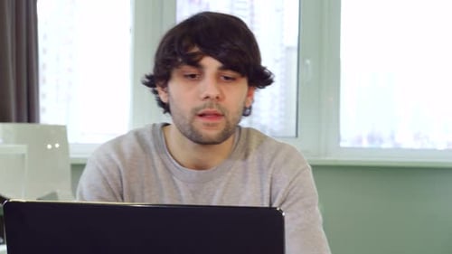 Young Adult Finishes Work and Stretches in Home