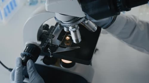Hands Using Microscope in Medical Laboratory