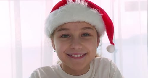 Smiling Child with Santa Hat at Home