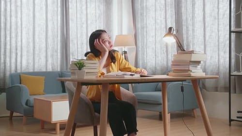 Young Asian Female Being Bored To Read The Books While Studying At Home