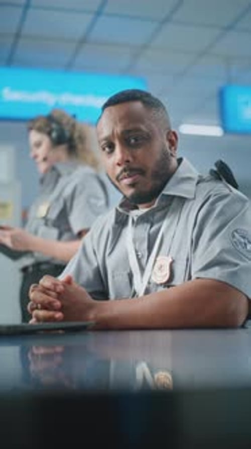 Airport Security Checkpoint Security Officer in Uniform Looking at Camera Work at TSA