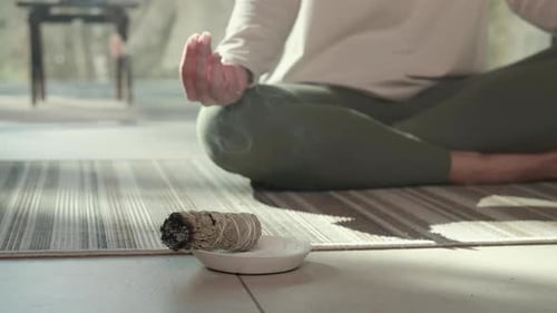 Person Meditating with Burning Sage Indoors
