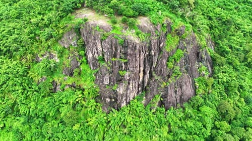 The rocky cliffs are surrounded by a tropical green rainforest. Drone view.