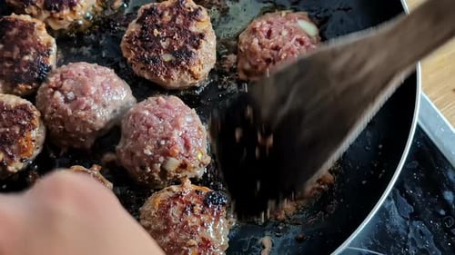 Fleischbällchen in einer Pfanne auf dem Herd anbraten - isoliert aus nächster Nähe