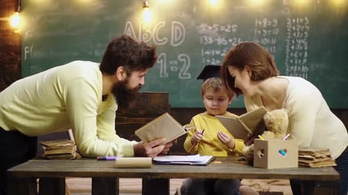 Boy From Elementary School Family with Little Child Boy Reading Book In Playroom Class Happy Cute