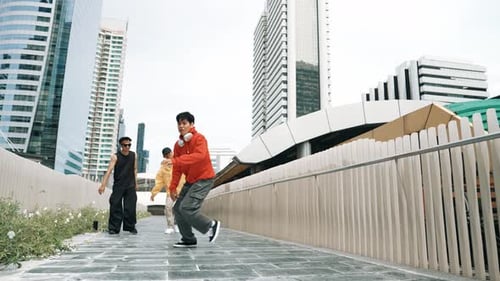 Professional hipster doing head spin while friend cheering him. Sprightly.
