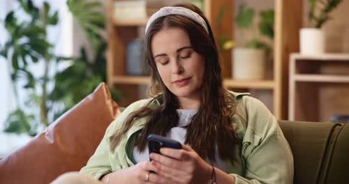 Woman Using Smartphone While Relaxing on Couch