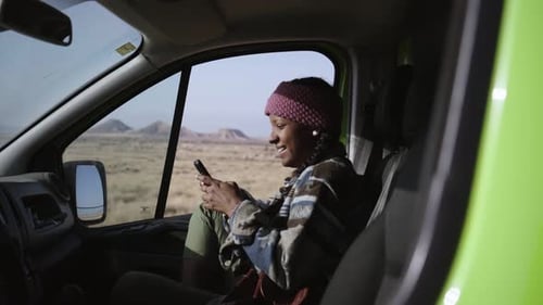 Woman Using Phone in Van in the Desert