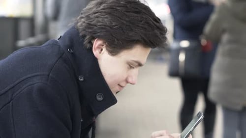 Young Teenager Surfing Internet, Texting on Smartphone in the City Adolescent