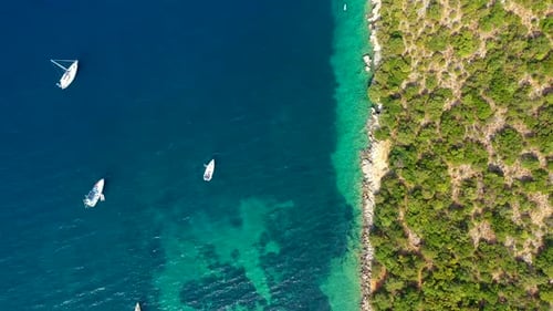 Yacht anchoring in crystal clear turquoise water in front of the tropical island, alternative lifest