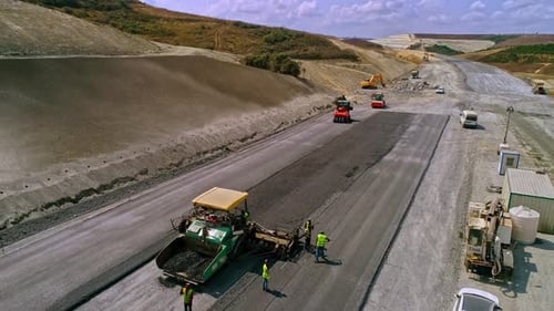 Aerial view of highway asphalt paving with construction machinery