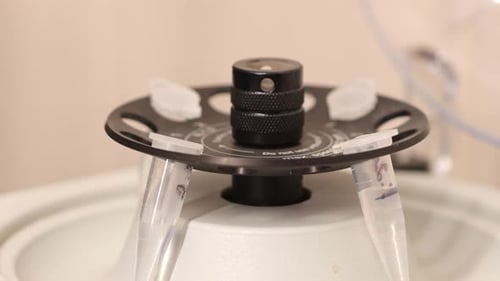 Close Up of Hand in Glove Placing Sample Tube in Centrifuge