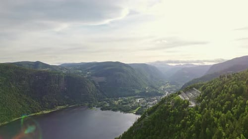 Norwegian River Surrounded By Dense Forest Mountains During Daytime