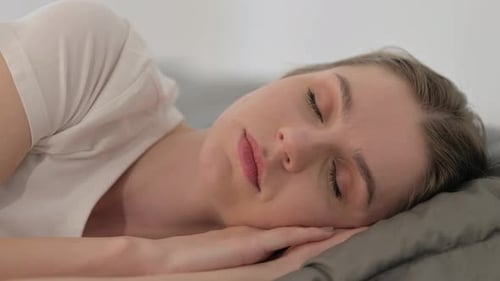 Close up of Woman Sleeping while Lying on Side in Bed