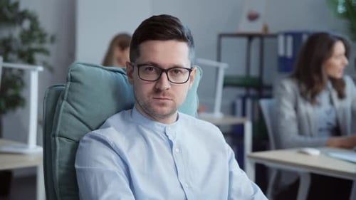 Closeup Portrait of Confident Young Office Manager Sitting at Desk in Modern Office Footage of
