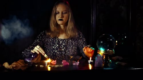 Rituel mystique de divination avec une boule de cristal psychique féminine, bougies fumées, améthyste et runes
