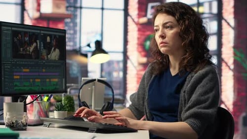 Video Editor Working at Computer in Modern Office